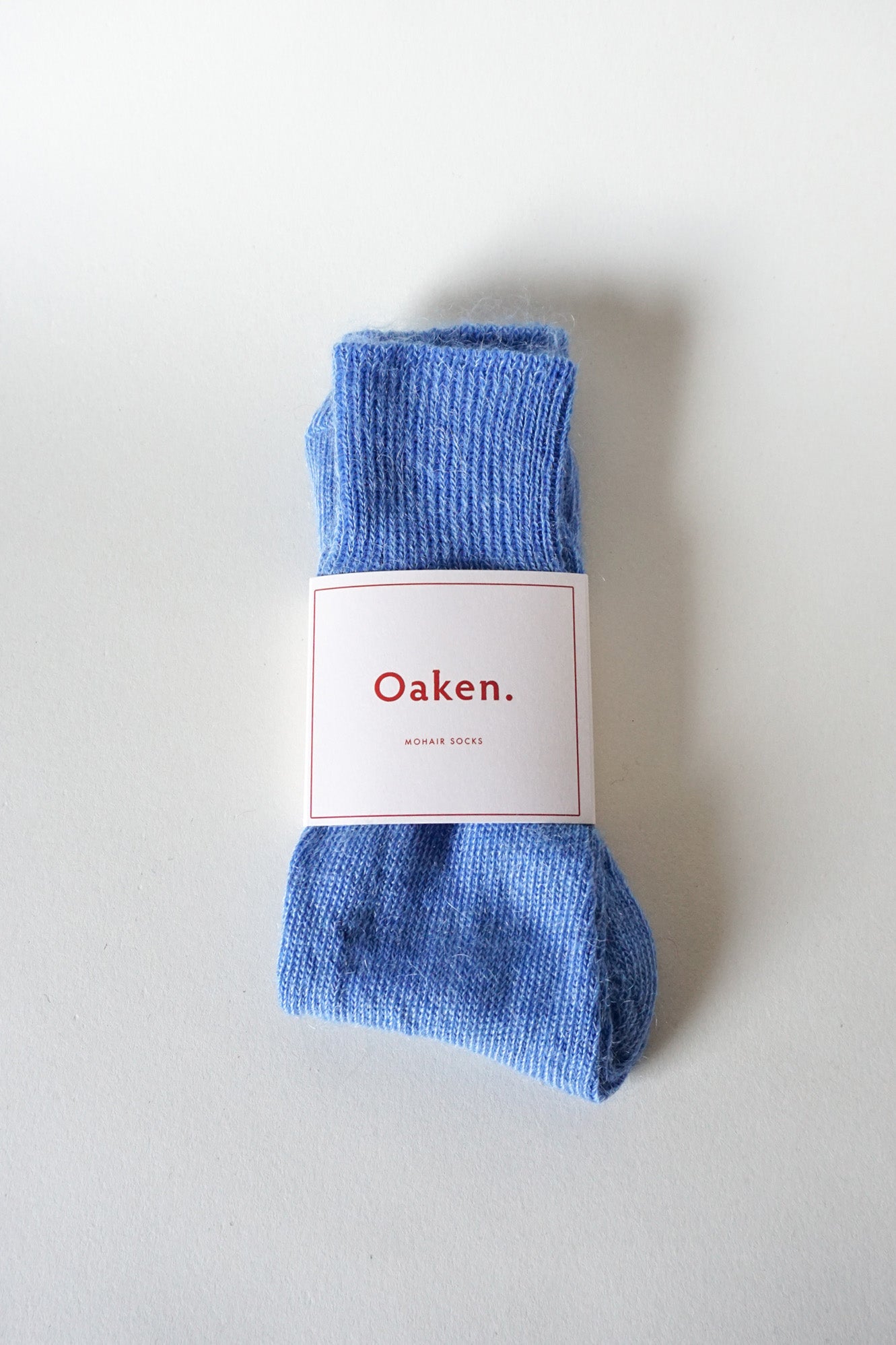 Women’s mohair calf length socks in cobalt blue with Oaken packaging, ideal for wearing with smart casual leather boots.