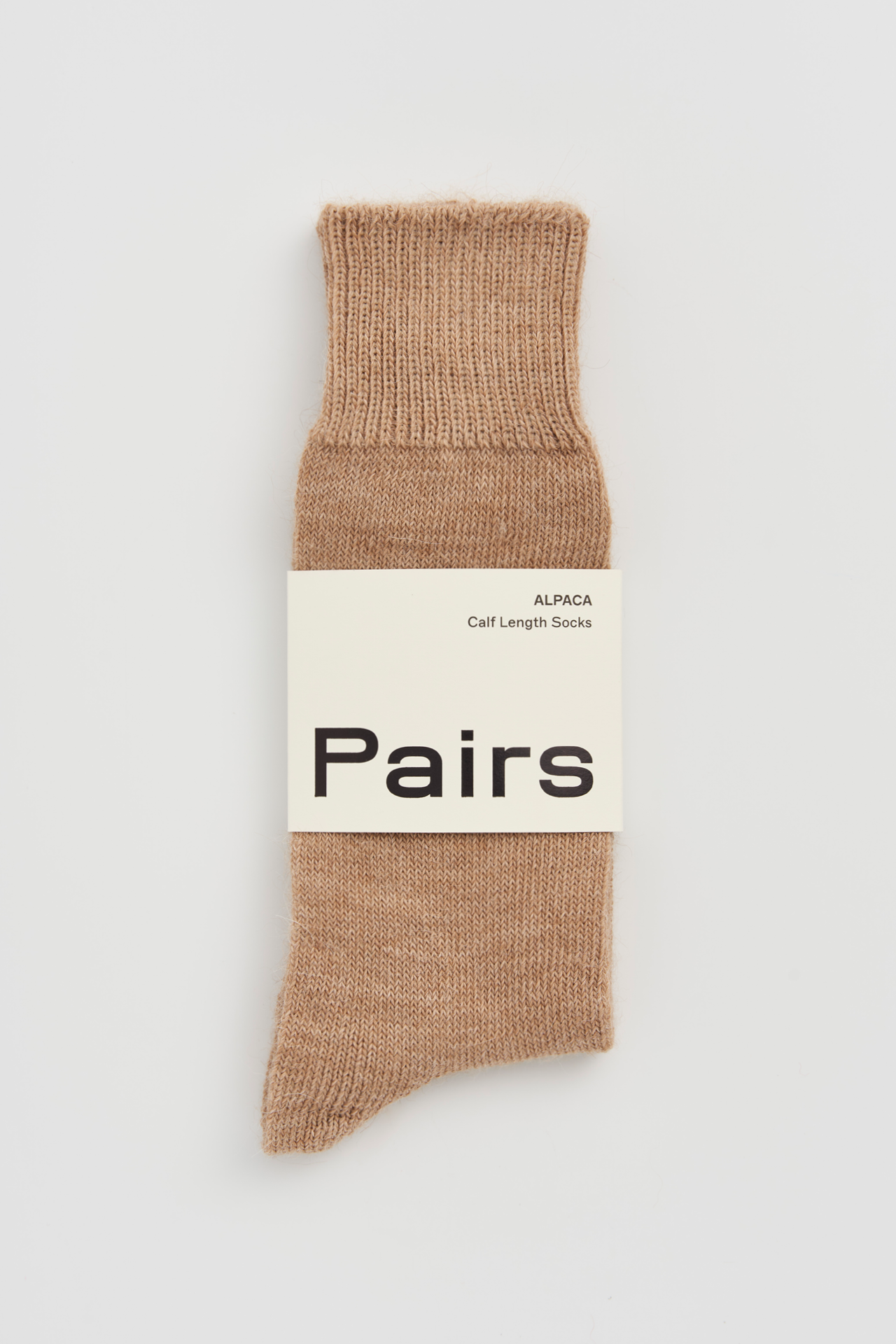 Women’s alpaca calf length socks in natural tan with Pairs packaging, ideal for wearing with smart casual leather boots.