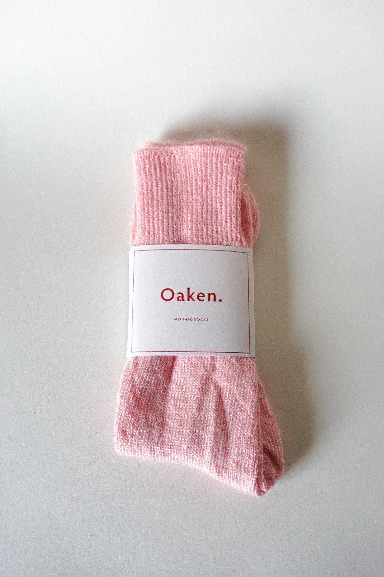 Women’s mohair calf length socks in light pink with Oaken packaging, ideal for wearing with smart casual leather boots.