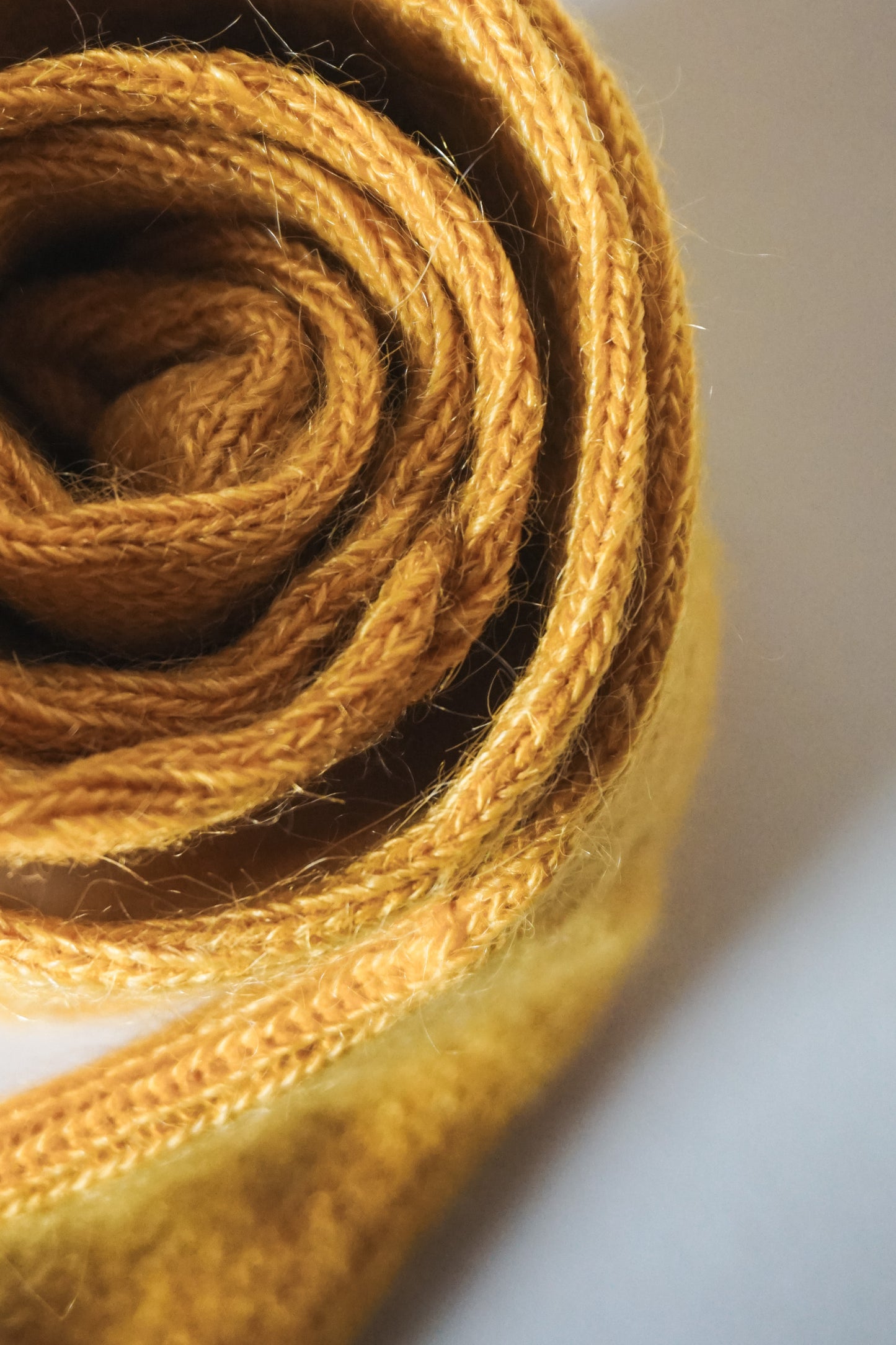 Women’s mohair calf length socks with ribbed cuff and soft knit texture for comfort when worn with leather boots. Close up view of socks rolled up.