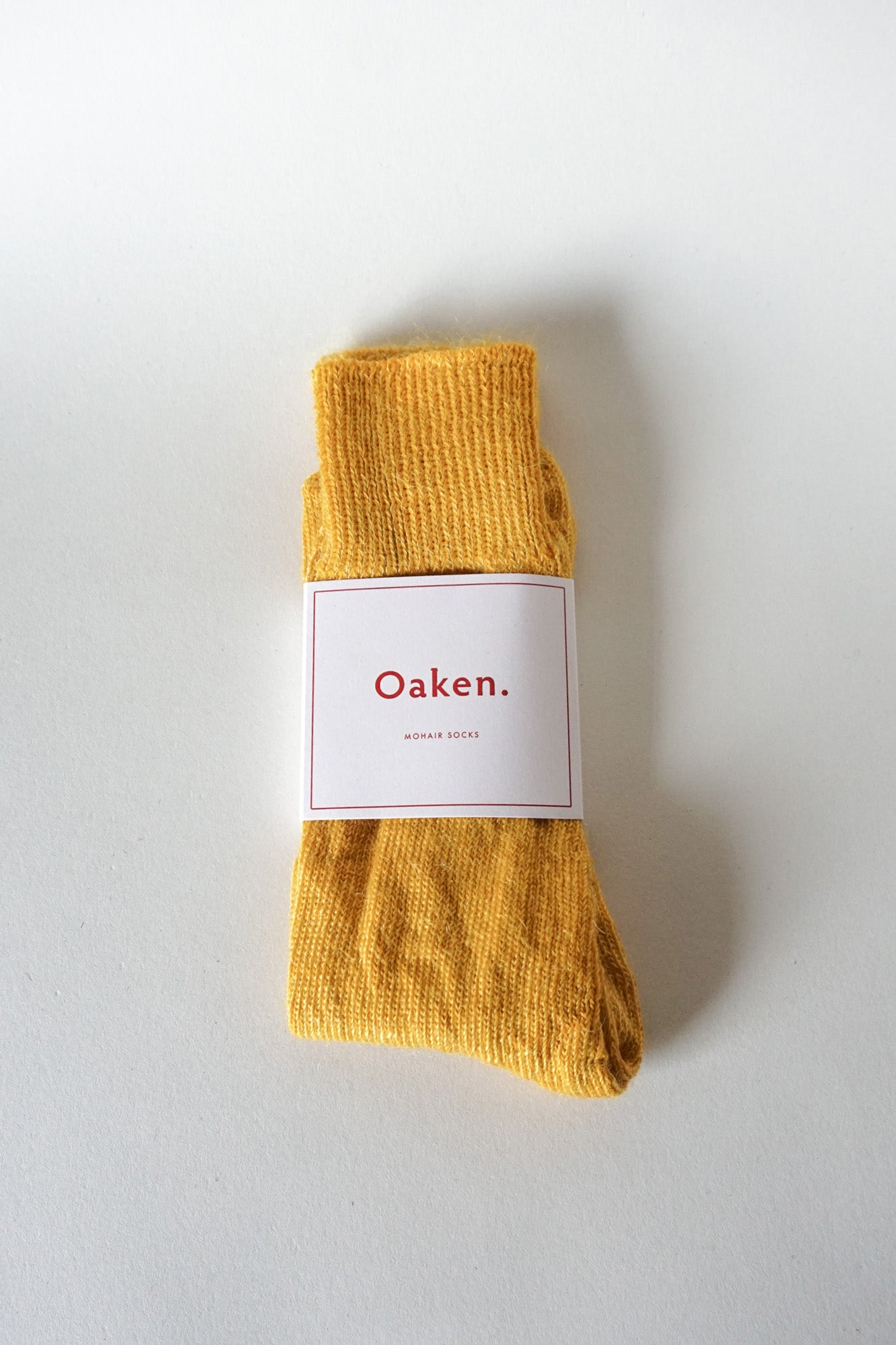 Women’s mohair calf length socks in yellow with Oaken packaging, ideal for wearing with smart casual leather boots.