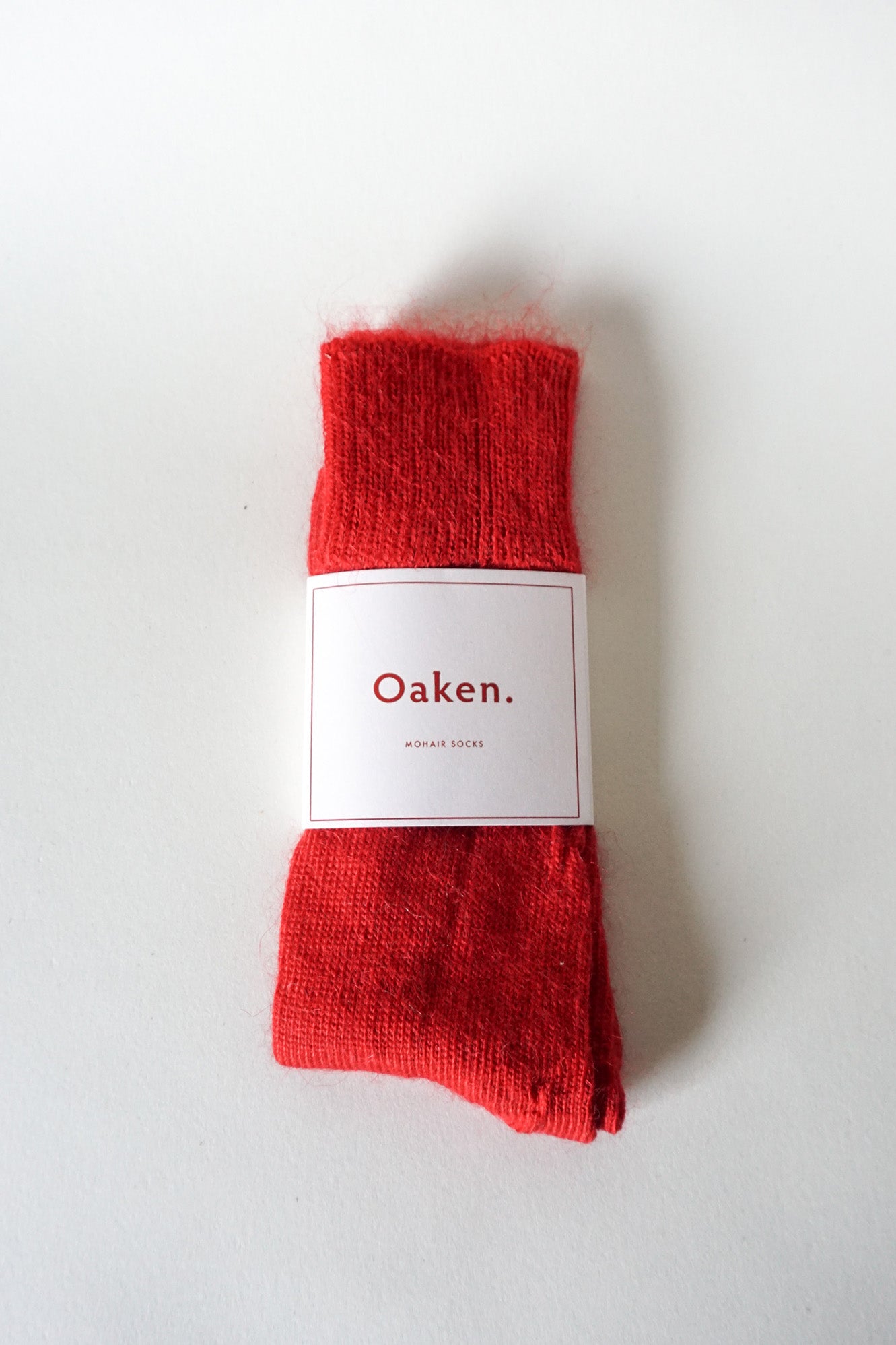 Women’s alpaca calf length socks in scarlet red with Oaken packaging, ideal for wearing with smart casual leather boots.
