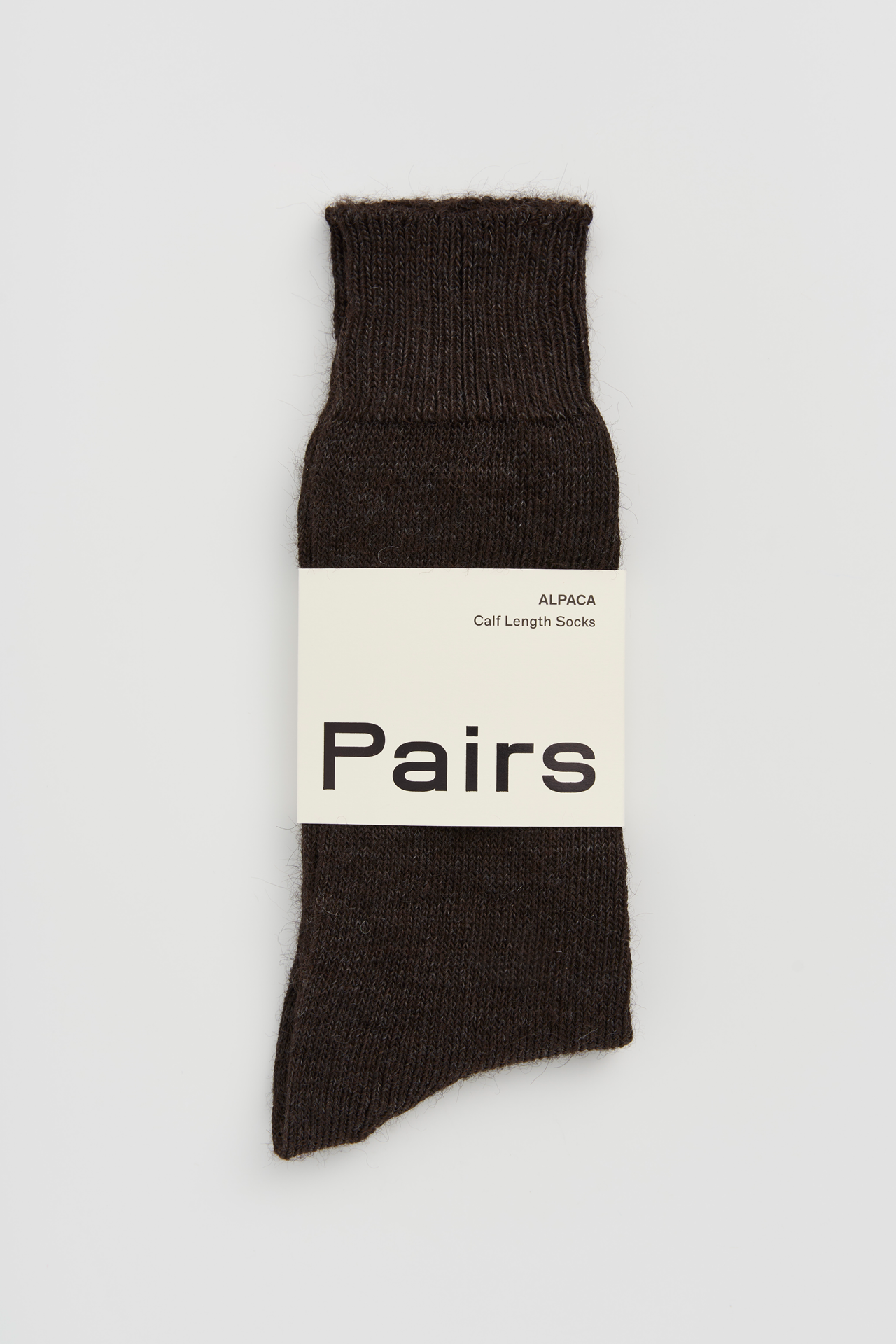 Women’s alpaca calf length socks in dark chocolate brown with Pairs packaging, ideal for wearing with smart casual leather boots.