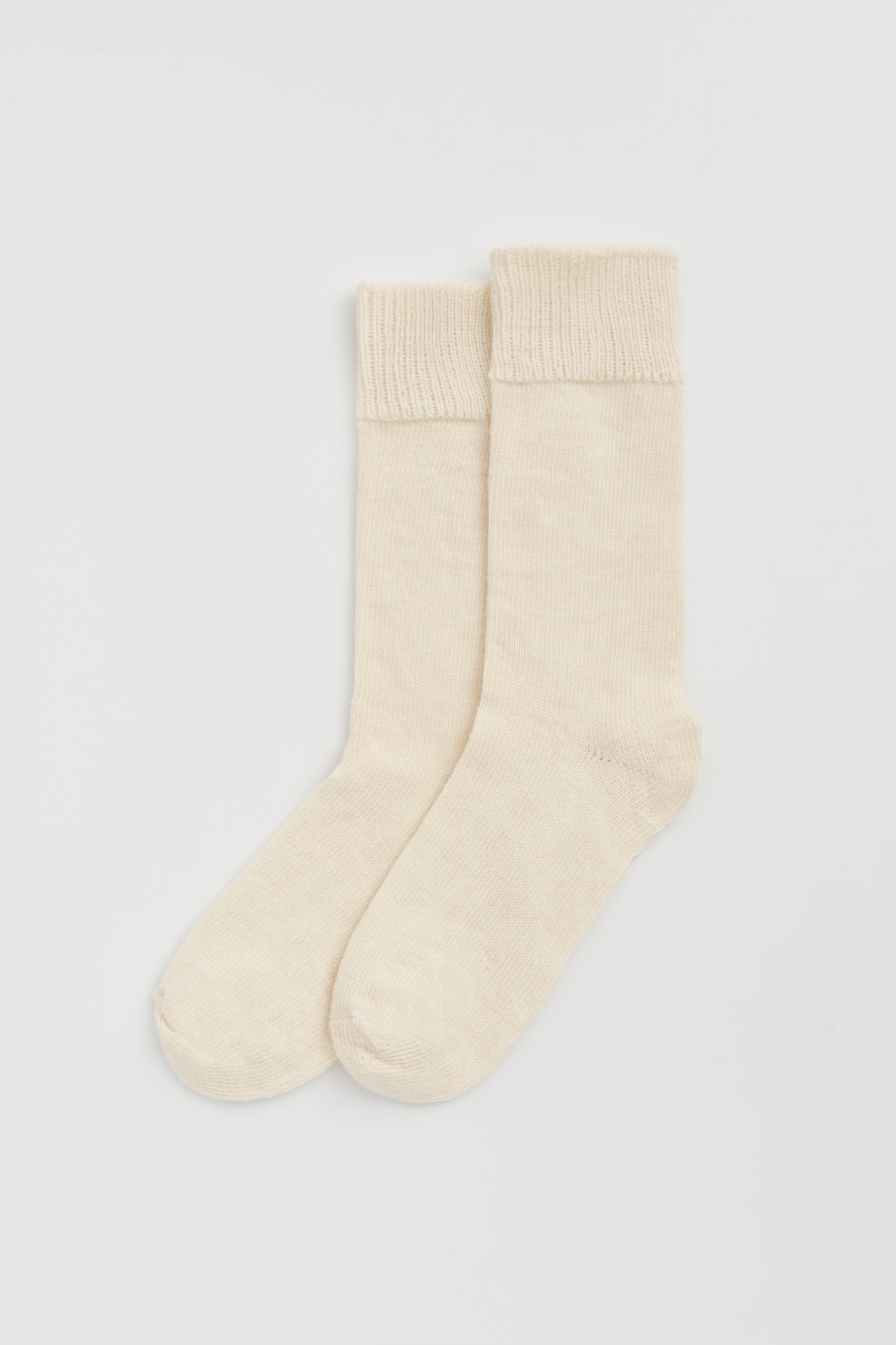 Women’s alpaca calf length socks in cream, shown as a pair laid flat, designed to wear with leather boots for warmth and comfort.